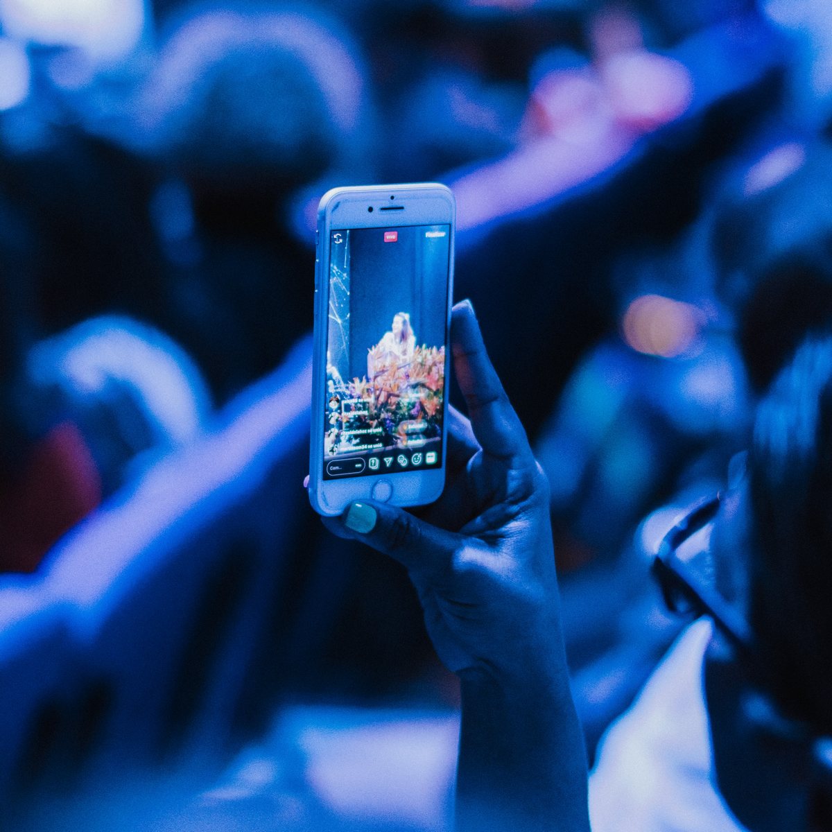 osoba sledující obrazovku smartphonu na modře osvětleném snímku